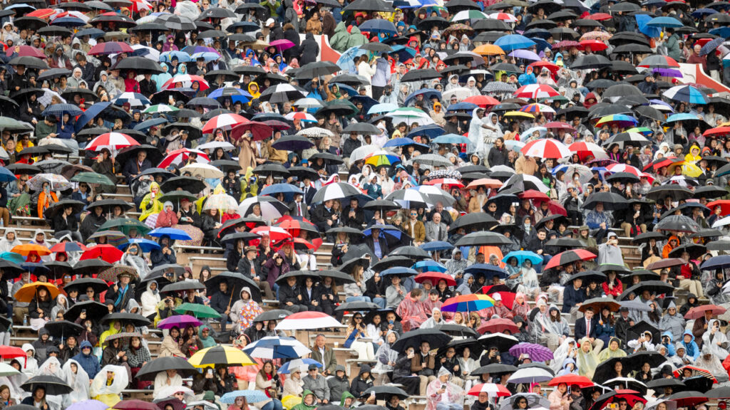 A view of hundreds of umbrellas keeping attendees sitting in the bleachers dry in the rain at Schoellkopf Field during commencement.