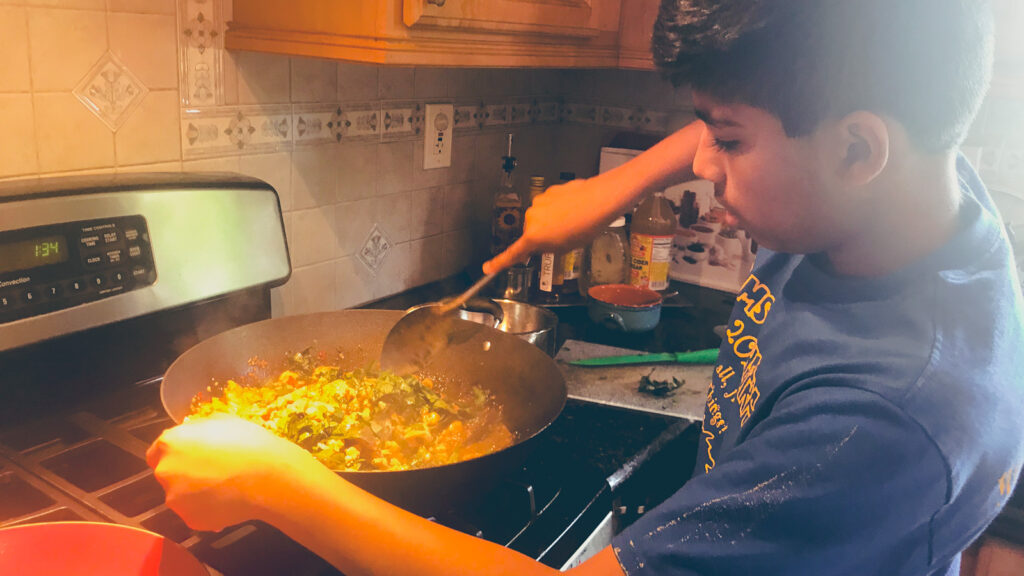 Arnav Kamulkar as a kid cooking food on his stovetop at home.