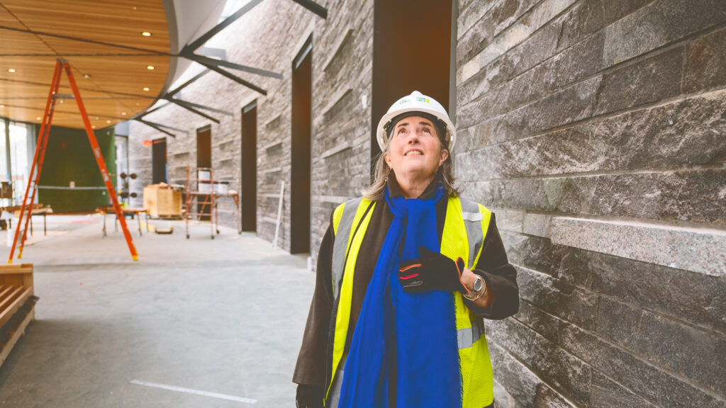Susan Rodriguez looks up at work progressing on the ceiling and skylight of the pavilion of the Davis Center at Harlem Meer in mid April