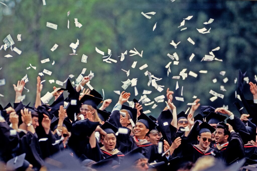 graduates throw fake paper money in the air during Commencement ceremonies in 1991
