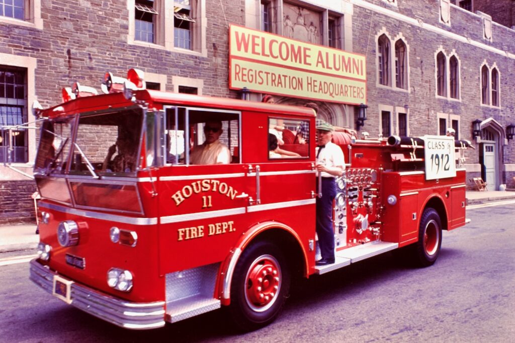 a fire truck, emblazoned with a sign reading "Class of 1912," arrives at alumni registration headquarters for Reunion 1967