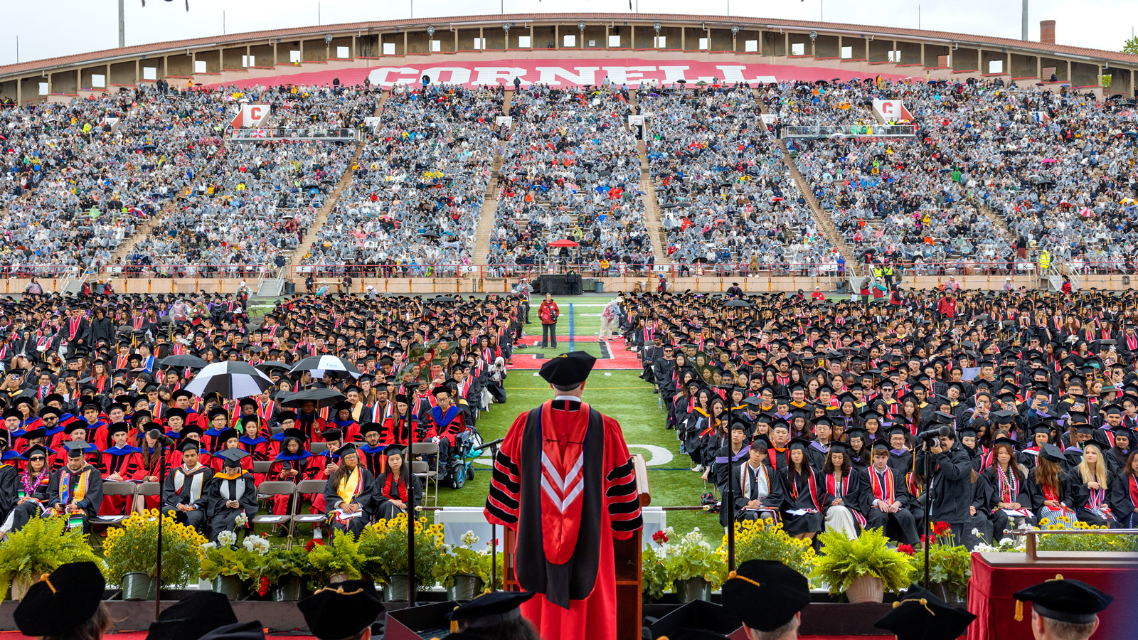 A view from the stage as President Mike Kotlikoff, academic regalia, speaks to the crowd during commencement at Schoellkopf Field.