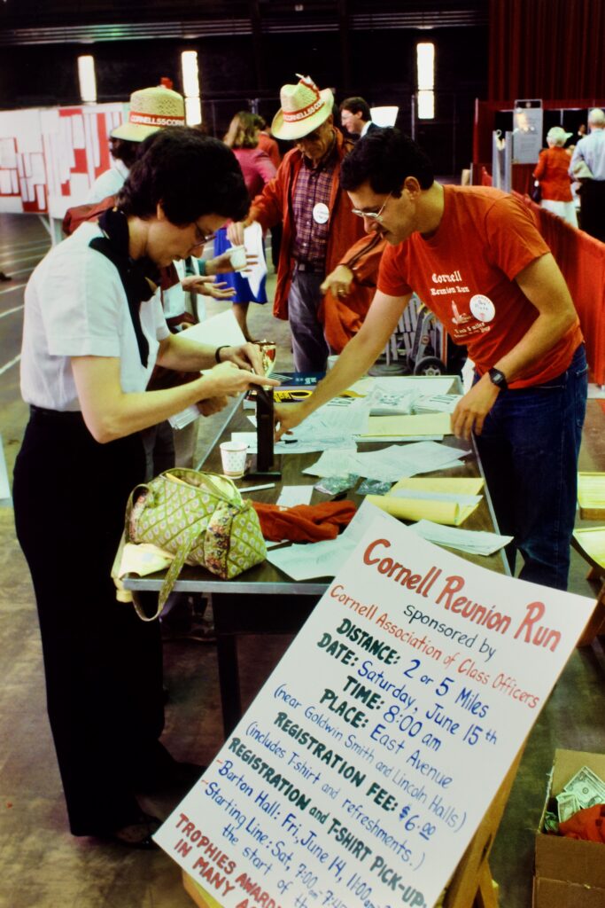Reunion volunteers and attendees at a table in 1985, signing up participants for the Cornell Reunion Run