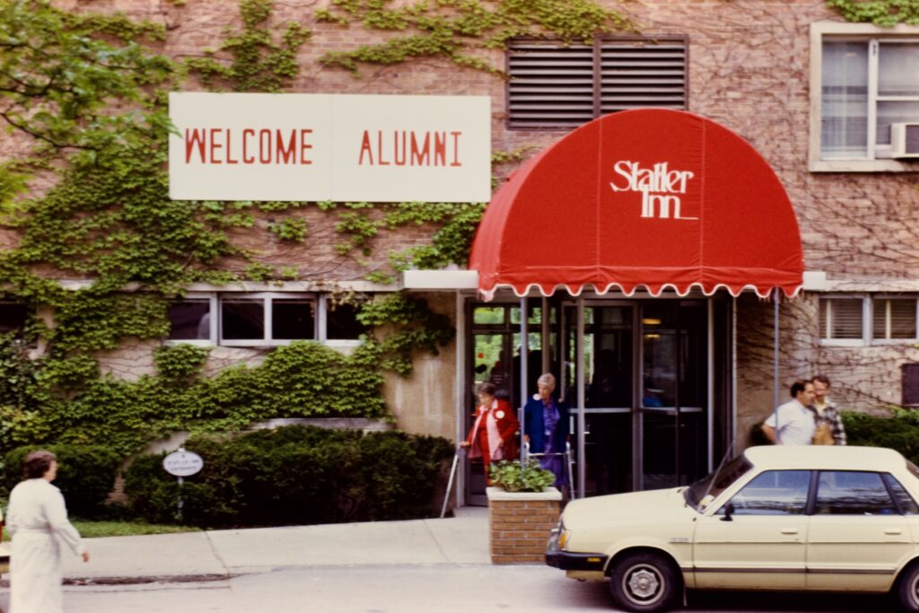 daytime view of the front of Statler Inn during Reunion 1985, with a "Welcome Alumni" sign visible
