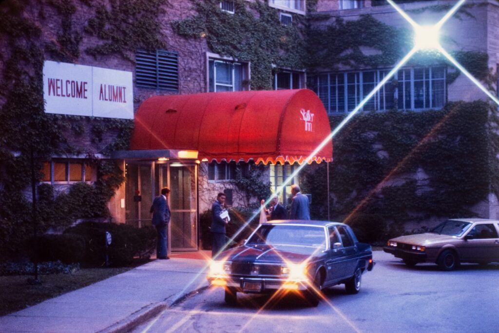 an evening view of the front of Statler Inn during Reunion 1985, with a "Welcome Alumni" sign visible