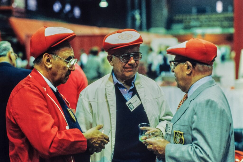 three male alumni from the Class of 1935 socialize in Barton Hall during Reunion 1985