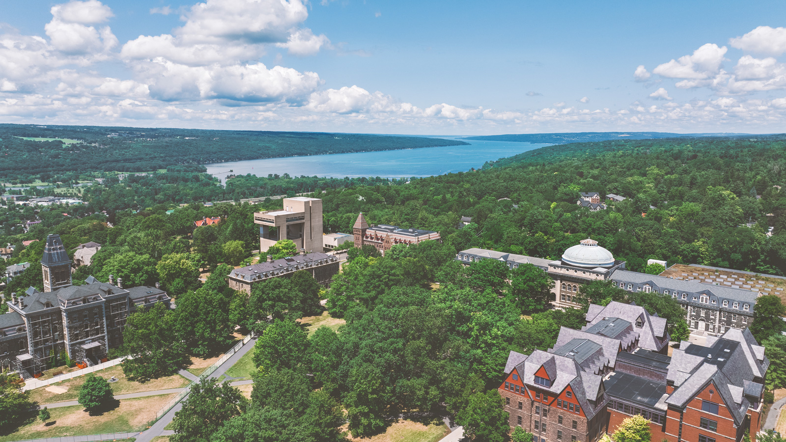 Aerial view of campus in the summer, with Cayuga Lake in the background.