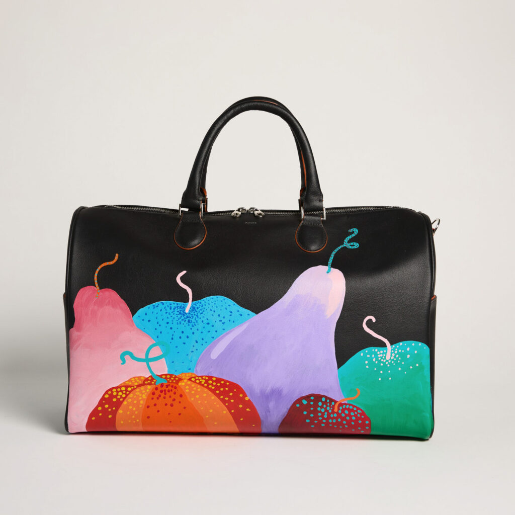 A black purse from Allegorie with brightly colored fruits painted on it in purple, blue, green, pink, orange, and red.