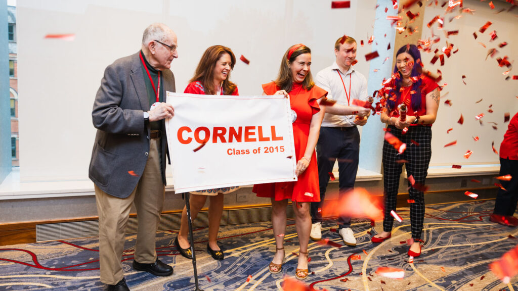 Alumni from the Class of 1950 pass the symbolic banner to the Class of 2015 at the Passing It Forward ceremony during Cornell Reunion in Statler Hall.