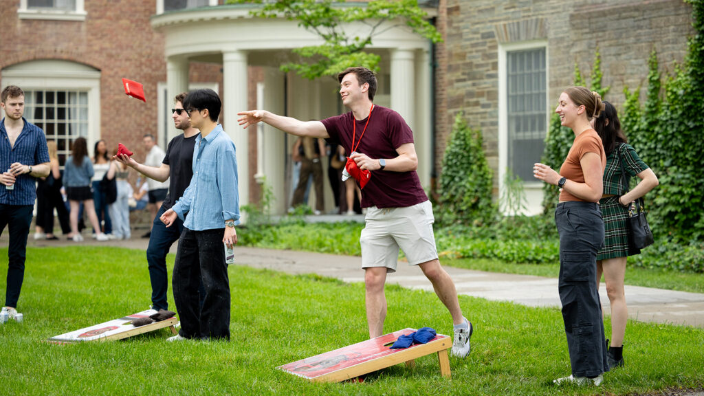 Alums play cornhole outside their reunion HQ