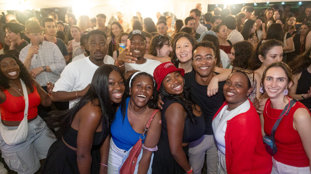 A group of smiling alumni at the tent parties on the Arts Quad