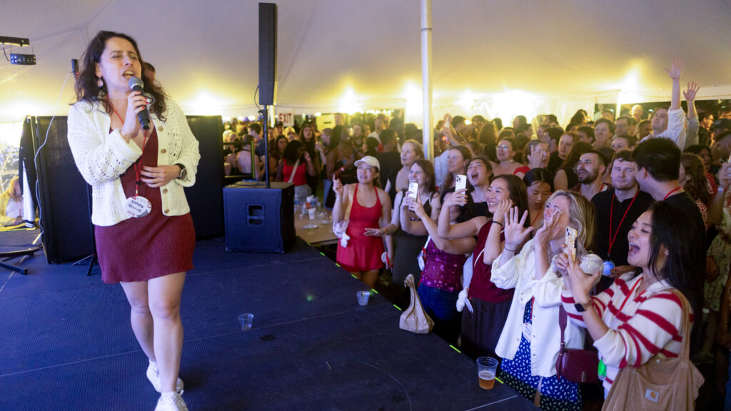 A woman performs karaoke during the tent parties on the Arts Quad