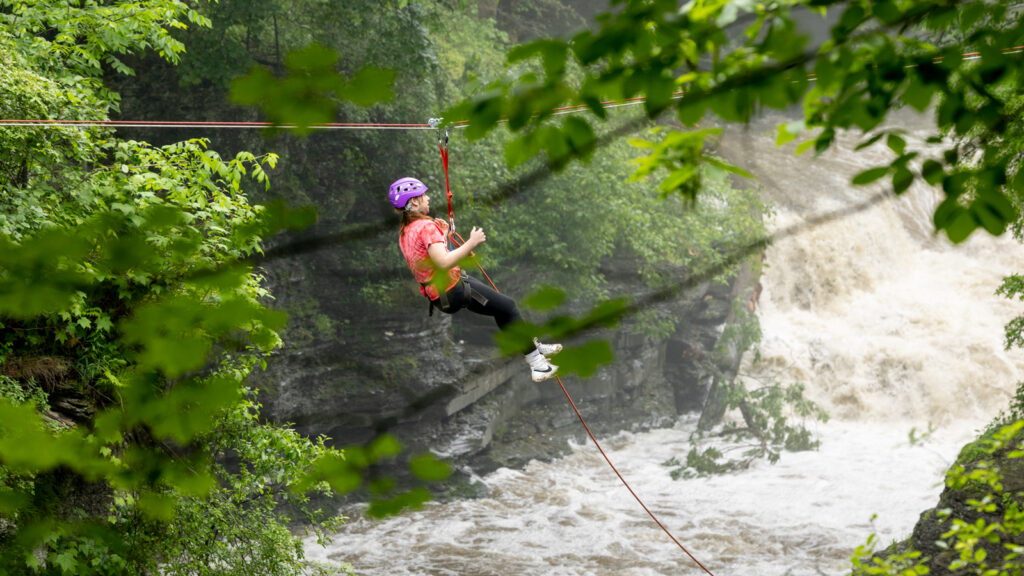 a woman ziplines over the gorge