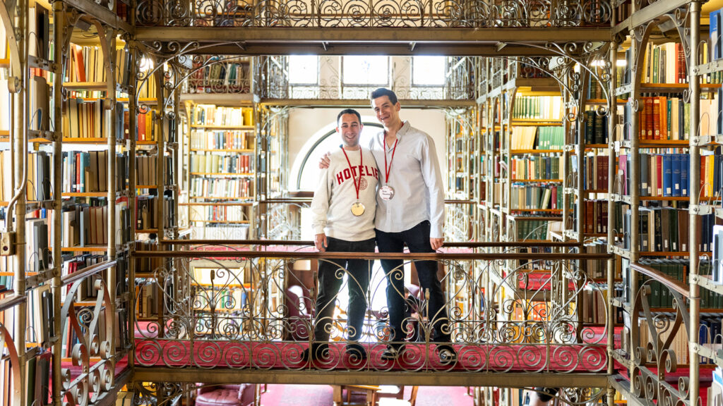 Two men pose in the AD White Reading Room