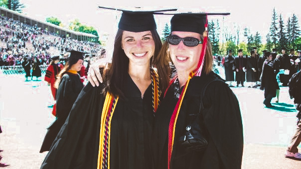 Alissa Jerud (left) and another graduate at Commencement, wearing caps and gowns