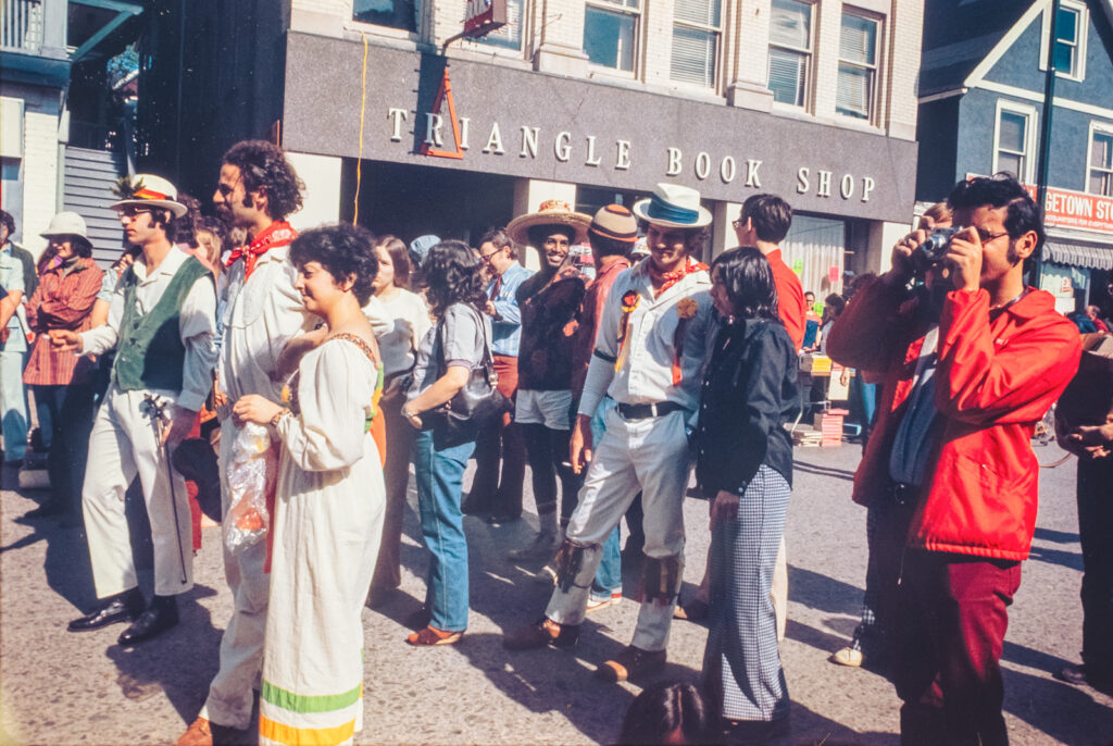 costumed attendees enjoy an event along College Avenue with the Triangle Book Shop in the background, 1974