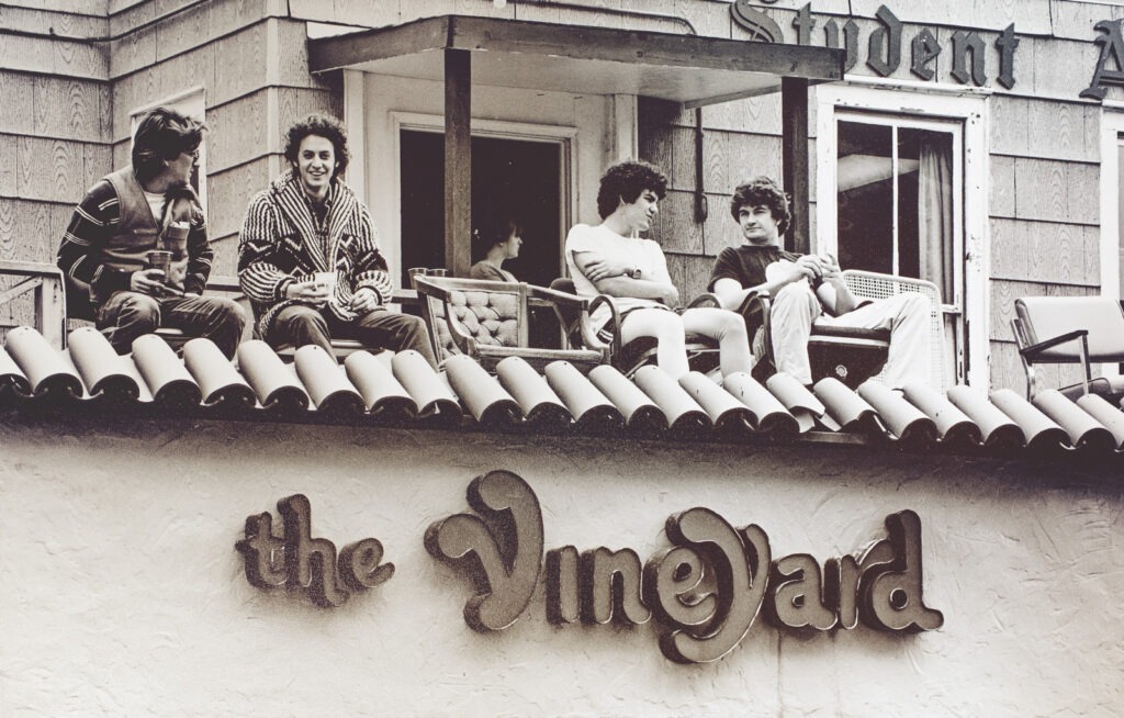students sit outside on the roof of the Vineyard at the Student Agencies building, 1982