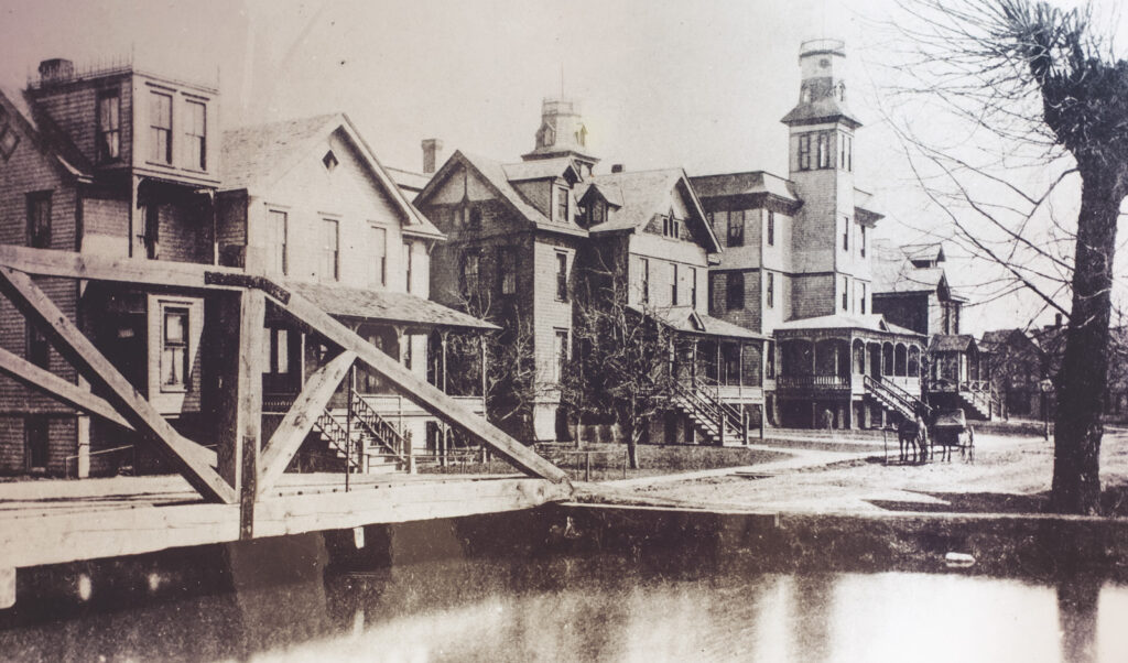the wooden Willow Creek Bridge crosses Willow Pond, then located at "Pop's Corner" at the north end of Heustis Street (later renamed College Avenue) at it appeared in the late 1800s