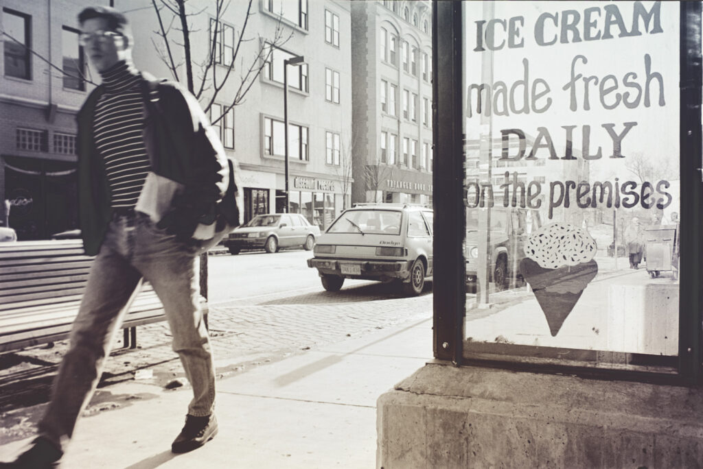 lettering on a bus stop shelter "Ice cream made fresh daily on the premises" along College Avenue in the 1970s