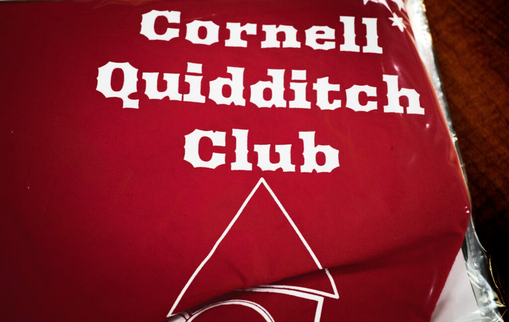 page of a student's scrapbook made for final project for AMST 2001 course that includes a folded t-shirt from the Cornell Quidditch Club