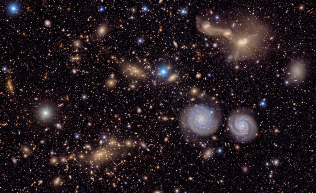This image captures a small section of NSF–DOE Vera C. Rubin Observatory’s view of the Virgo Cluster, offering a vivid glimpse of the variety in the cosmos. . Visible are two prominent spiral galaxies, three merging galaxies, galaxy groups both near and distant, stars within our own Milky Way, and much more