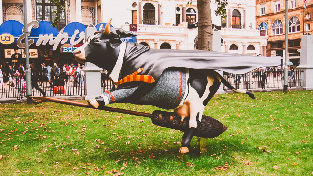 A fiberglass cow designed like Harry Potter riding a broomstick