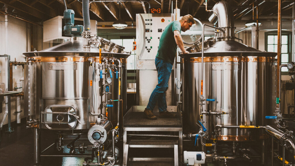Derek Edinger examines one of the tanks at the brewery