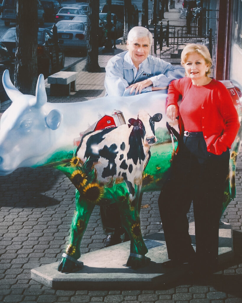 Jerry & Judy Elbaum with a fiberglass cow with a cow painted on it