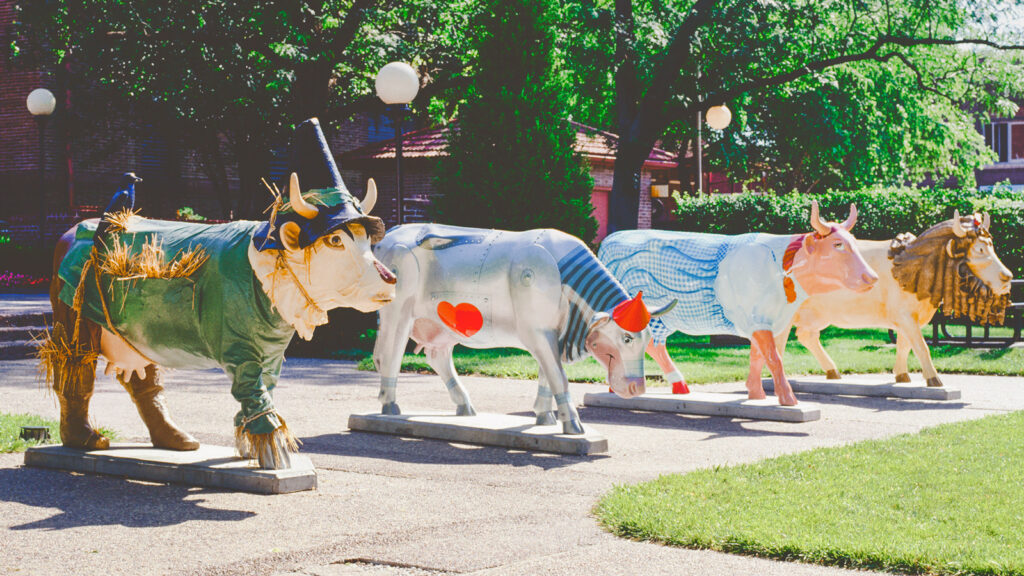 Four fiberglass cows designed like Wizard of Oz characters