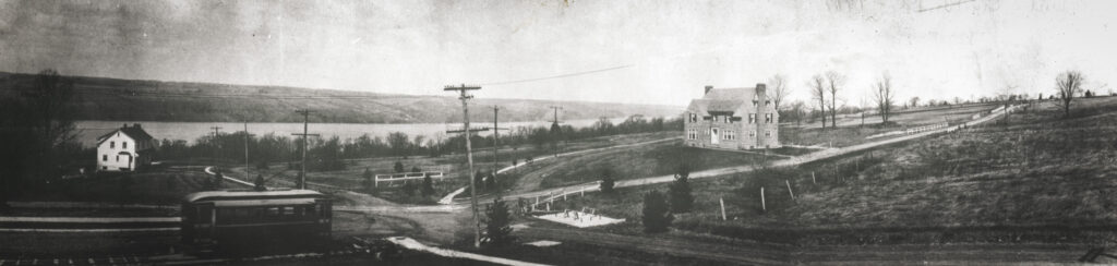 A panoramic image of upland road from 1917, depicting a few houses and a trolley
