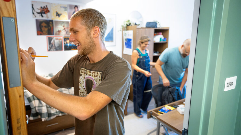 A student and his parents set up in his residence hall room during Move-In Weekend, 2025