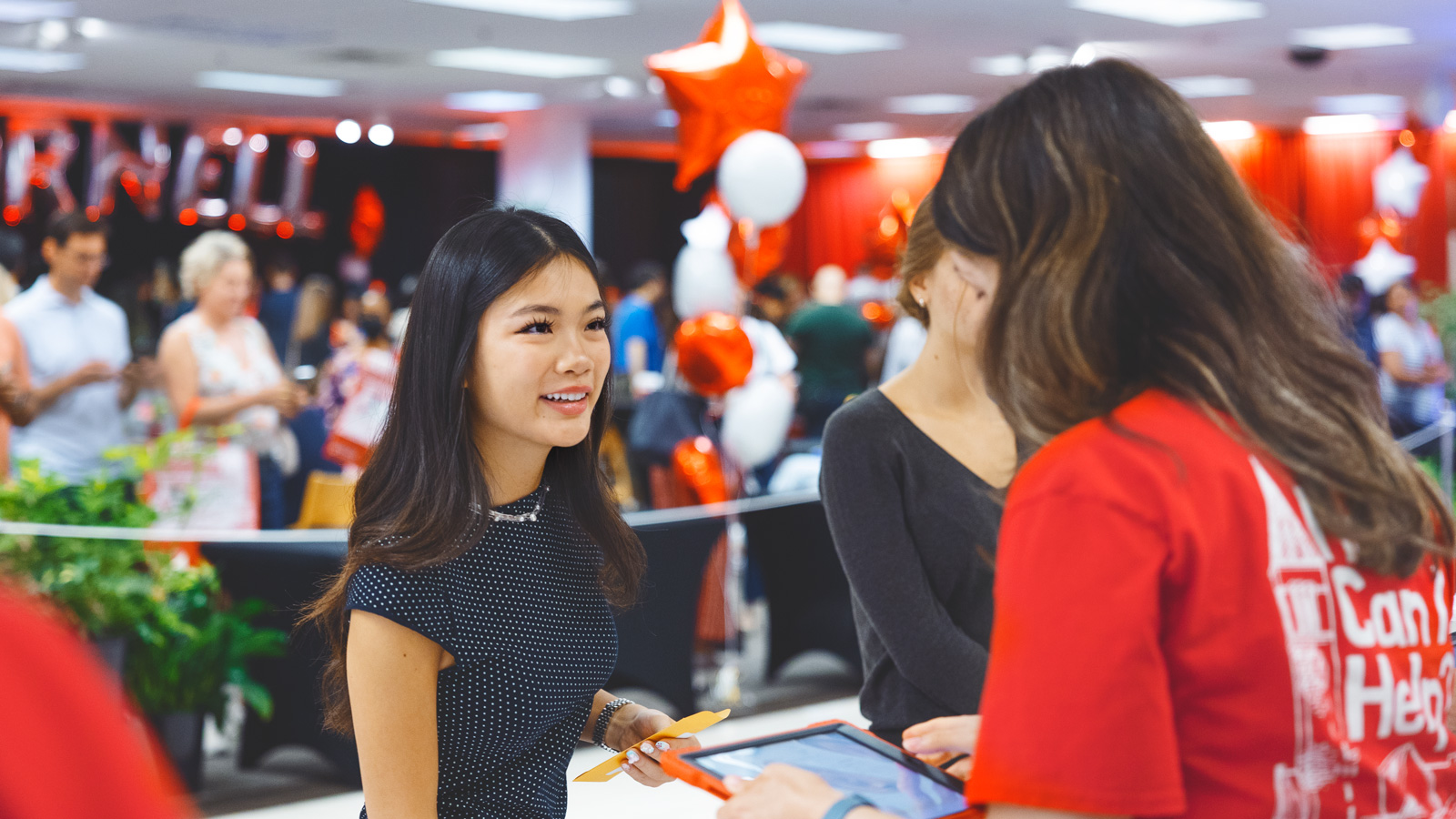 A student chats with a volunteer at welcome center at the Ithaca mall during Move-In Weekend, 2025