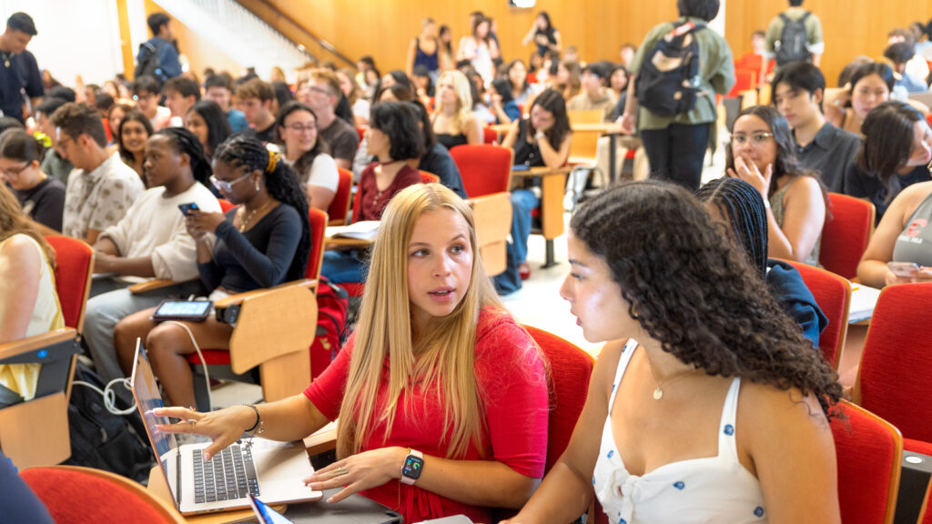 Students chat in a lecture hall on the first day of classes, fall 2025