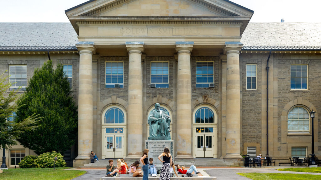 Students sit and stand outside of Goldwin Smith Hall on the opening day of fall semester 2025.