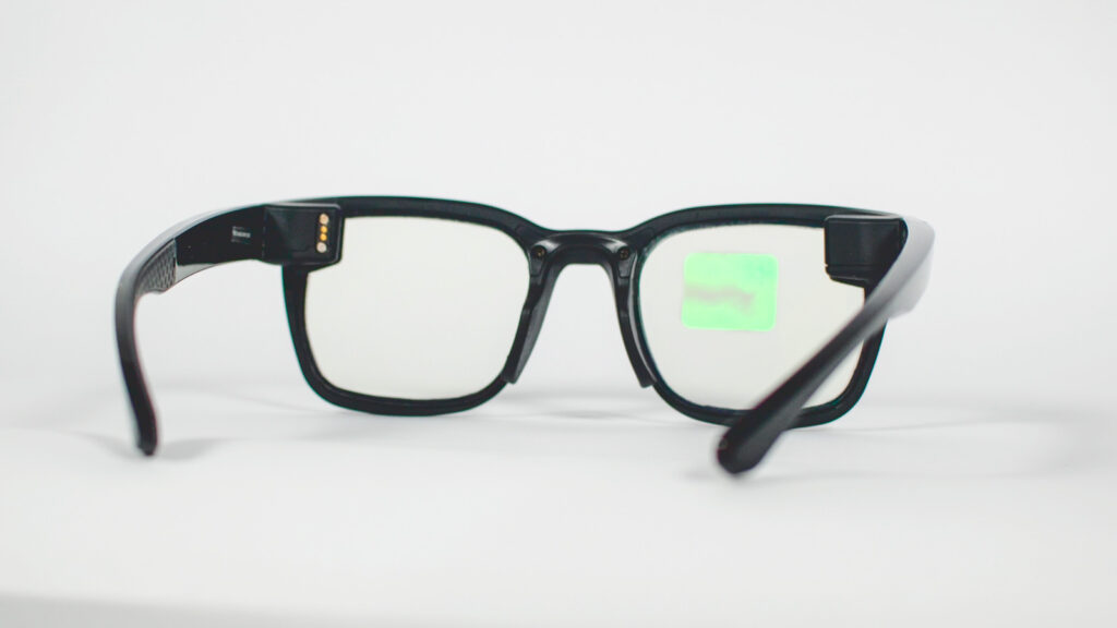 A pair of the black, smart glasses sitting on a white surface.