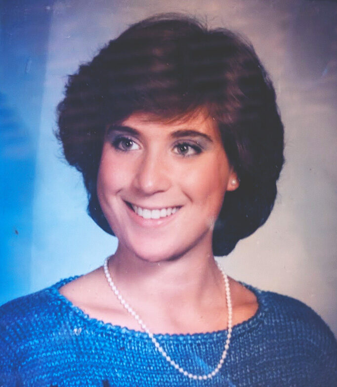 Laura Winter Falk wearing a blue sweater and pearl necklace in her Cornellian yearbook photo.