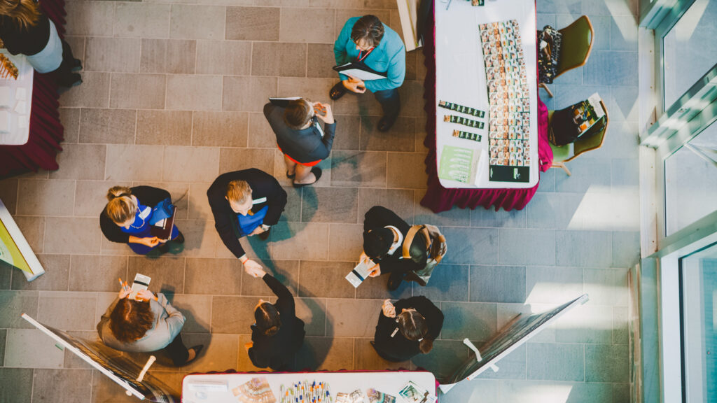 An overhead photo of a job fair with people shaking hands