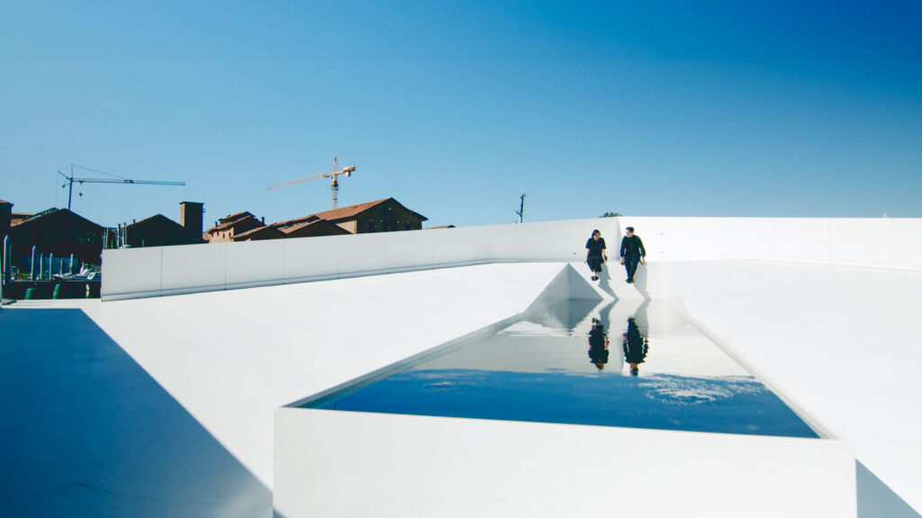 Meejin Yoon and Eric Höweler are reflected in a pool on the AquaPraça exhibit.