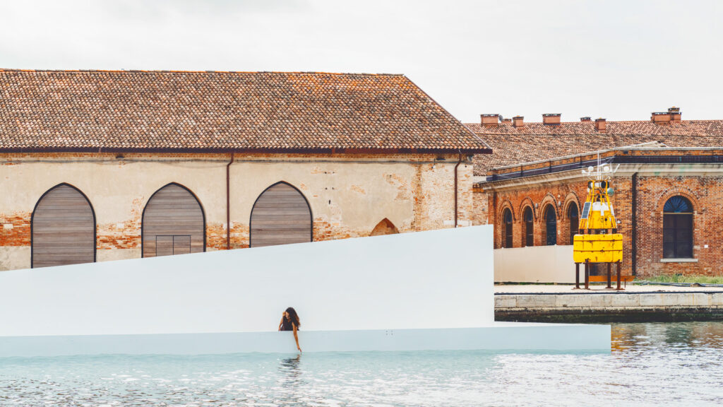 A side view of the AquaPraça exhibit, with a woman dipping her hand into the water.