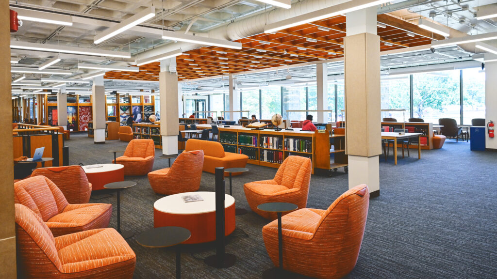 new study tables, seating, and shelving, along with the new Arts Quad entrance, are visible in this view of the renovated main floor of Olin Library