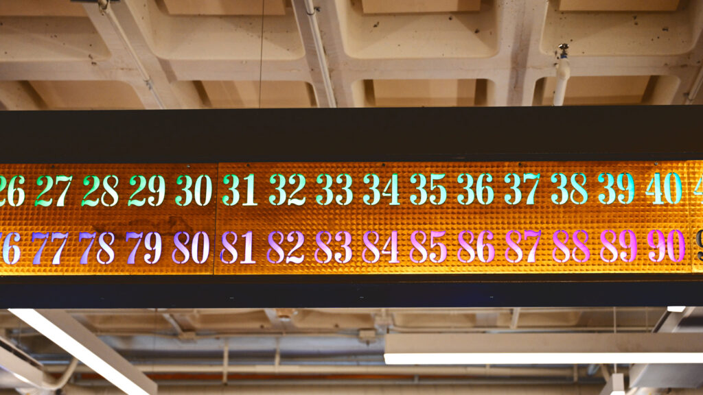 a portion of the the repurposed call board, with new multicolored LED lights having replaced the old incandescent bulbs