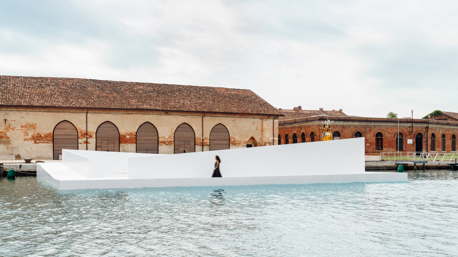 A side view of the AquaPraça exhibit, with a woman walking on it.