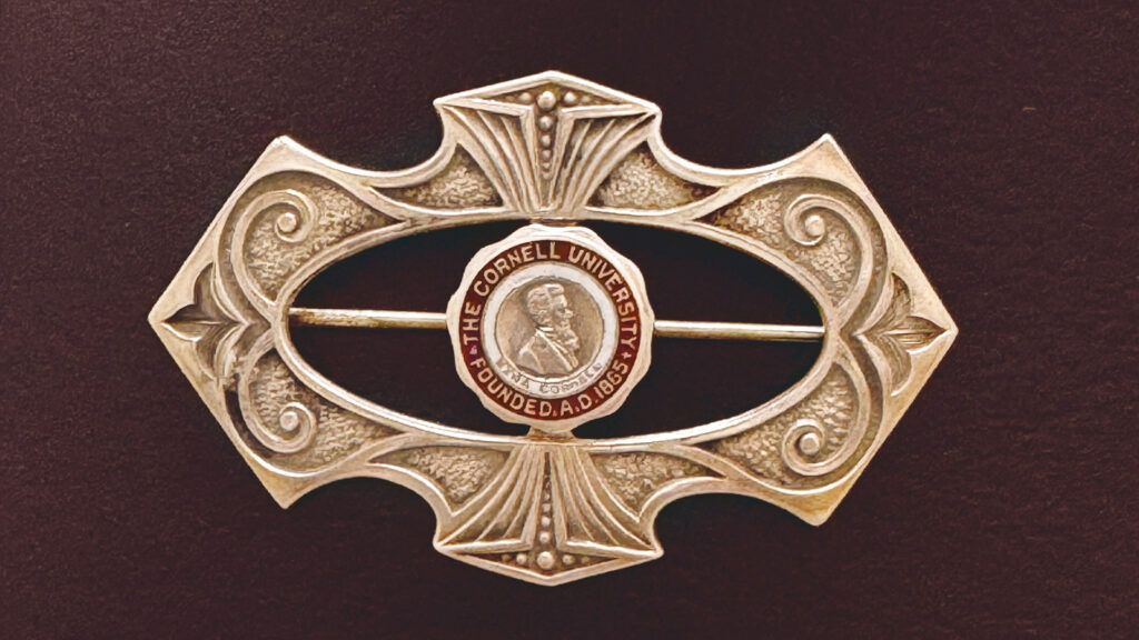 an elaborate vintage gold brooch with the University seal at its center