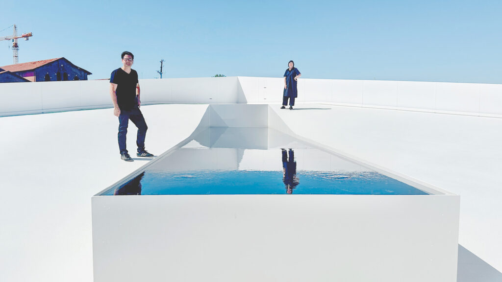 Meejin Yoon and Eric Höweler stand near a pool on the AquaPraça exhibit.