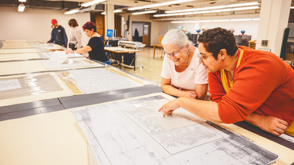 patrons look at maps on display in the Olin Library Map Room, which saw its entrance renovated as part of the 2025 redesigns