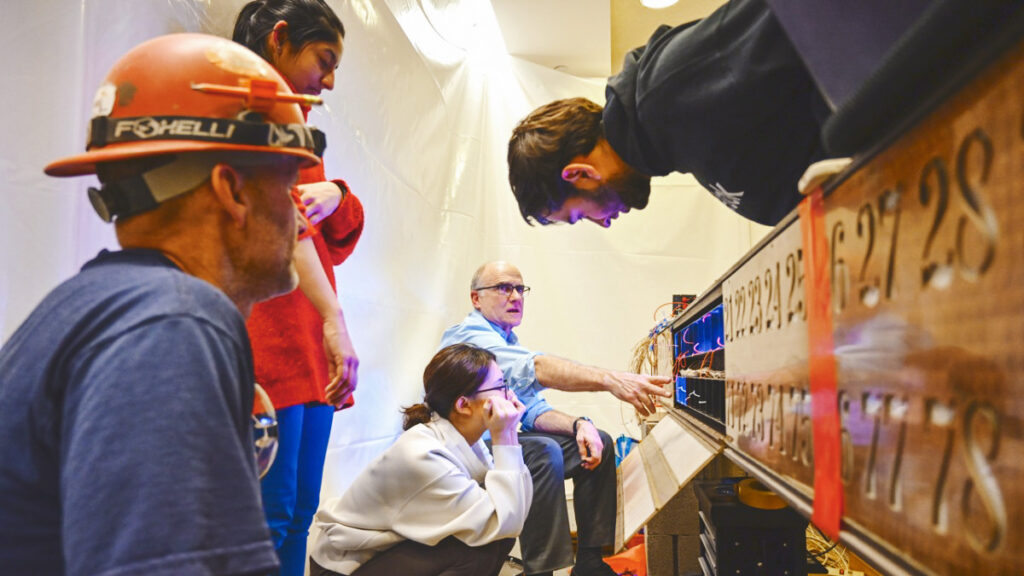 professor Joe Skivora, PhD ’90, and his engineering students work on the rewiring of the iconic Olin Library call board display, during which they installed a computer, used new multicolored LED lights to replace old incandescent bulbs, and reused as much of old the wiring as possible