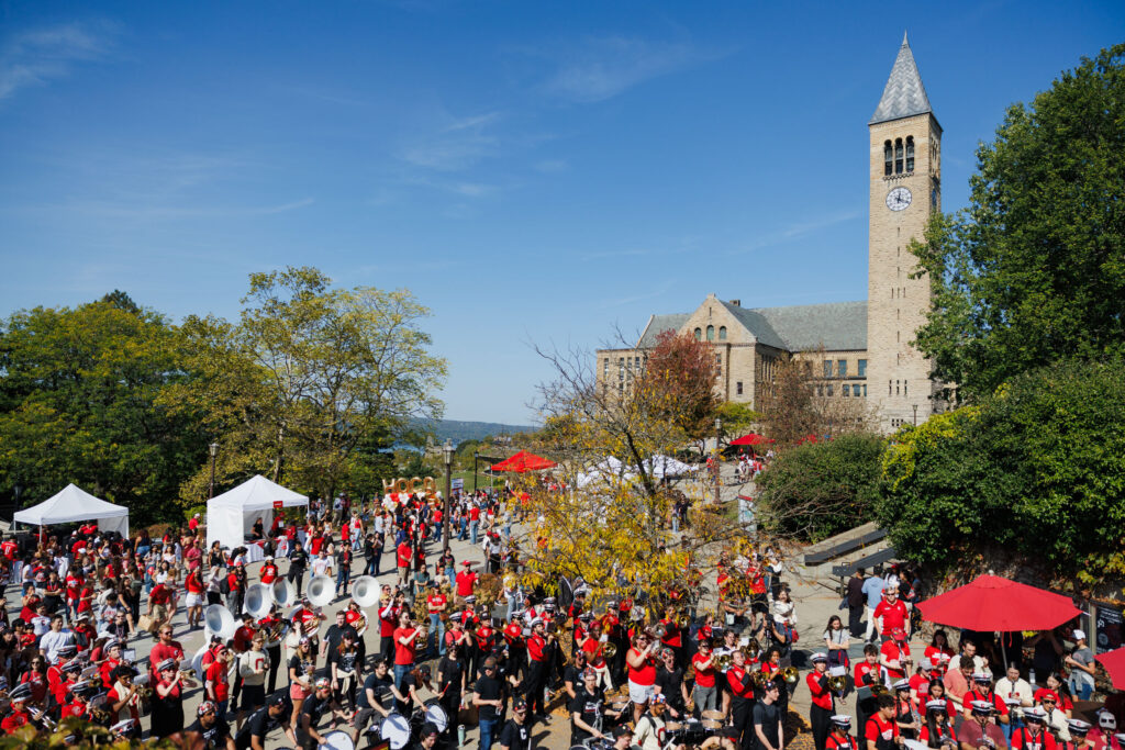 A view of homecoming near the clocktower including several white and red tents and the Big Red Band playing.