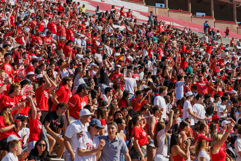 The bleachers at Schoellkopf Field packed with fans wearing red and white during the homecoming game.