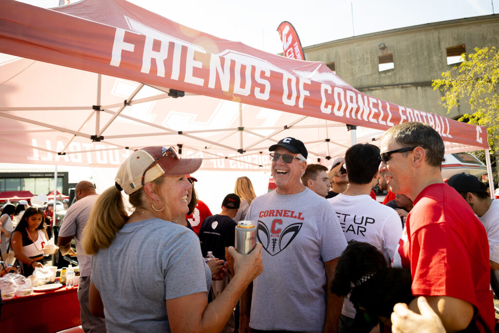 Fans socialize in front of the "Friends of Cornell Football" tent during the homecoming tailgate.