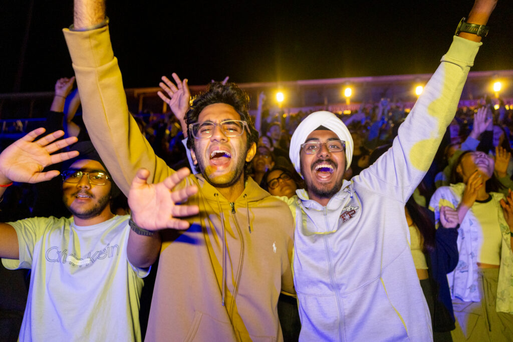 Students cheer during the drone and laser show in Schoellkopf Field.
